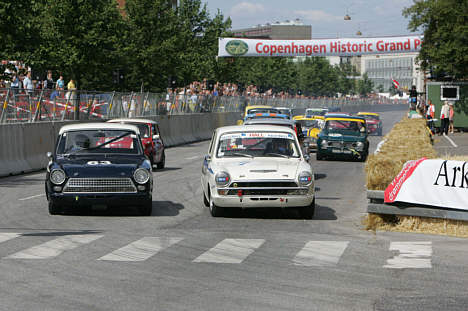 Benny Hall (i den hvide Ford Lotus Cortina til højre i billedet) var hurtig i sidste års Copenhagen Historic Grand Prix. Det er han også i år, men han får med garanti kamp til stregen i et felt, som tæller flere højpotente, kraftsvulmende biler som f.eks. Ford Mustang og Ford Falcon.